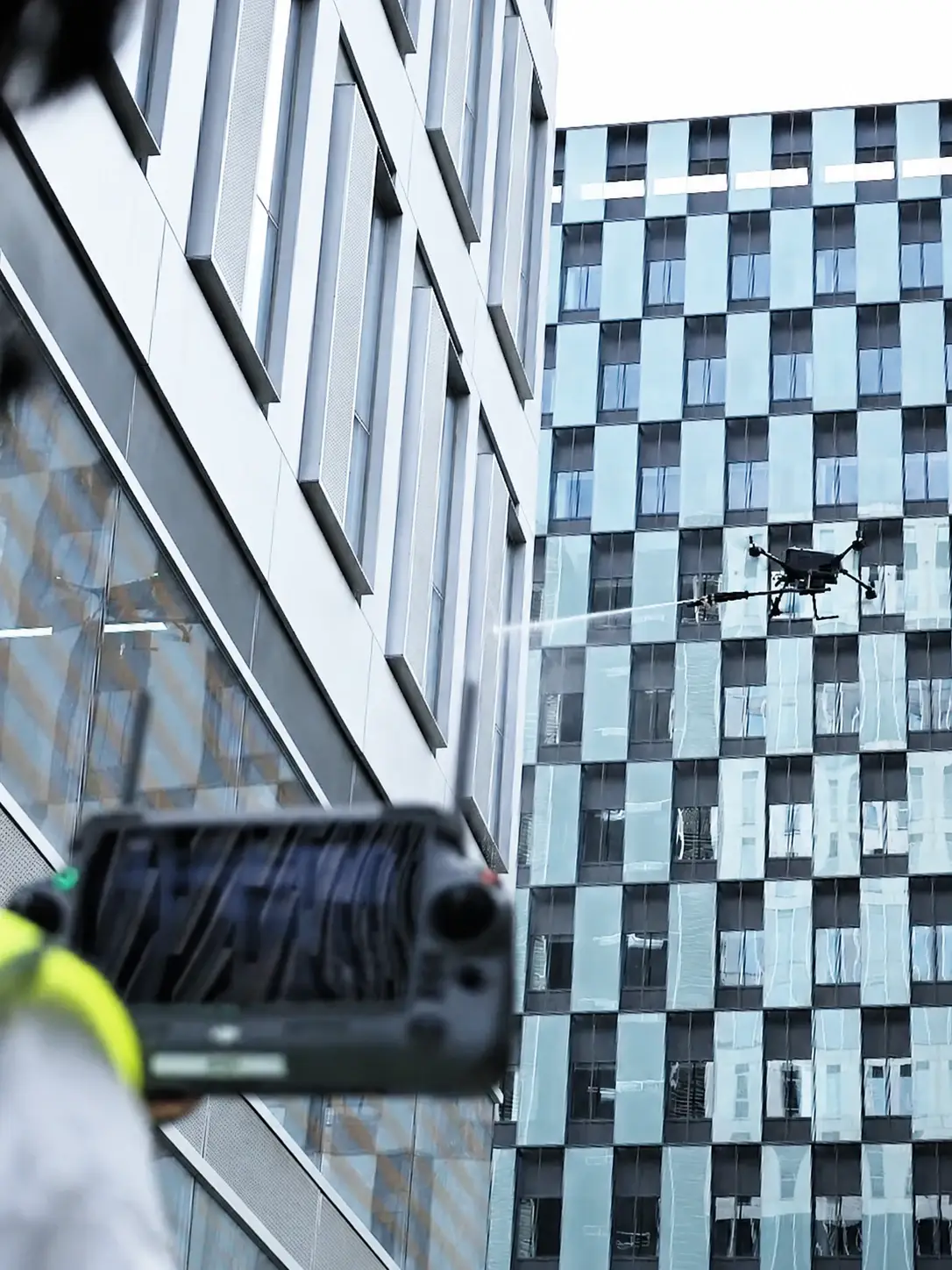 DJI Matrice 400 using SkyFlow HoverWash 3 on a commercial facade