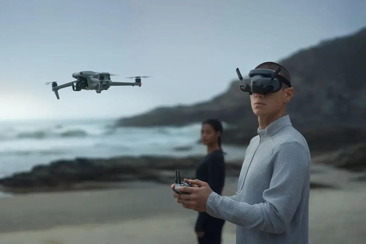 Pilot wearing DJI Goggles 3 on a coastline
