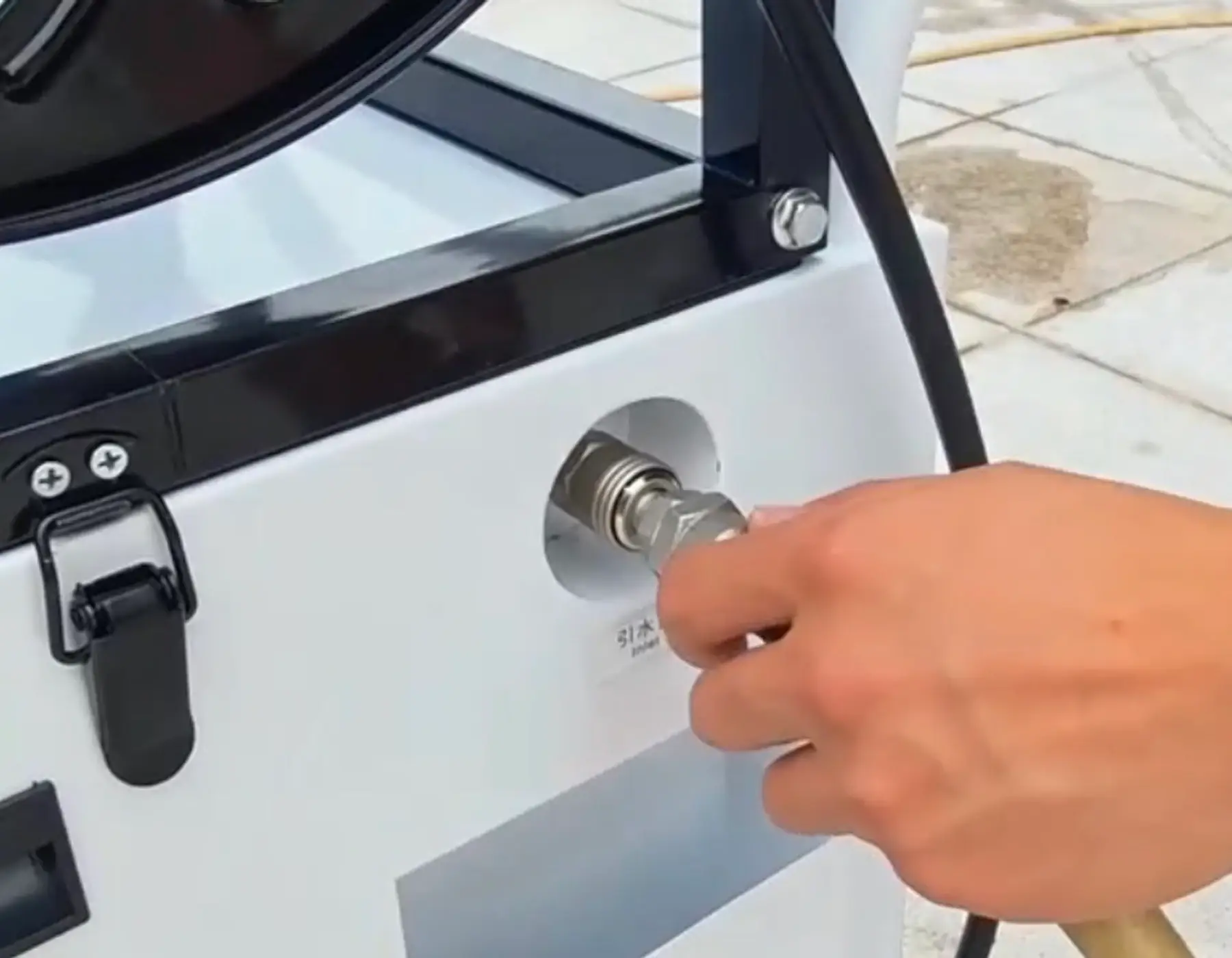Operator attaching the water supply connection to HoverWash Rig 13